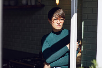 Pensive woman at home looking out of window