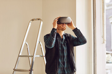 Man refurbishing shop location, using VR glasses