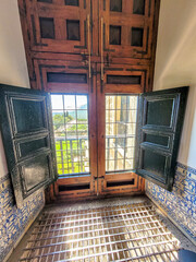 A regular park in the castle through a window with a metal grille