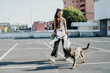 Naklejka premium Woman walking with dog in parking lot