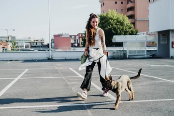 Poster Im Rahmen Woman walking with dog in parking lot © tunedin
