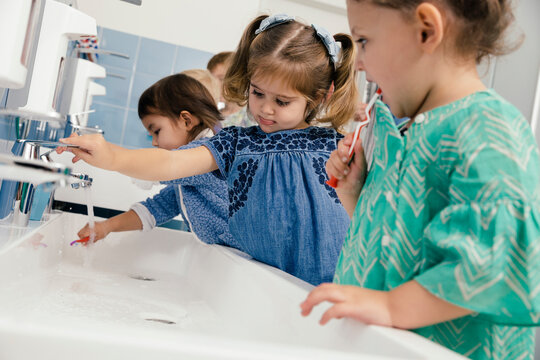 Children Brushing Their Teeth In Bathroom Of A Kindergarten