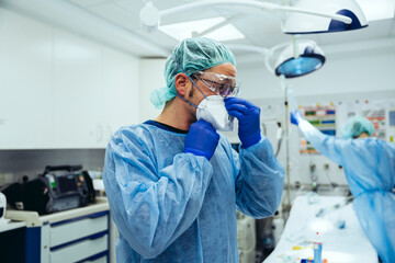 Doctor putting on ffp2 mask in emergency room of a hospital