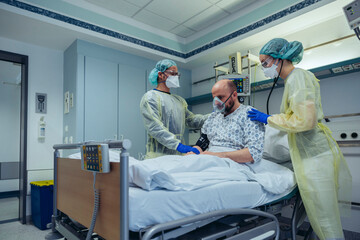 Doctors giving artificial respiration to patient in emergency care unit of a hospital
