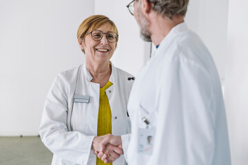 Two smiling doctors shaking hands