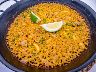 Spanish paella with seafood in a black pan in the restaurant