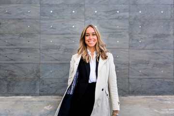 Portrait of happy businesswoman wearing trench coat