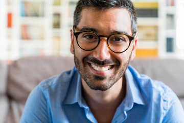 Portrait of happy young man wearing glasses at home