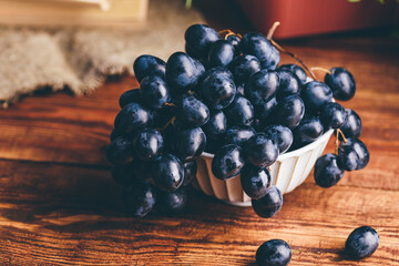 Vintage Bowl of Dark Blue Grapes on Wooden Table