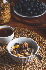 Granola with Dried Fruits and Chocolate in a Bowl and Cup of Black Coffee