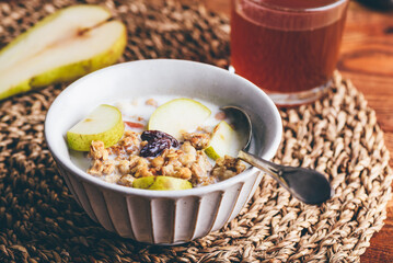 Homemade Granola with Fresh Pear and Milk in Vintage Bowl