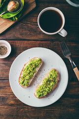 Avocado toasts and coffee on rustic table