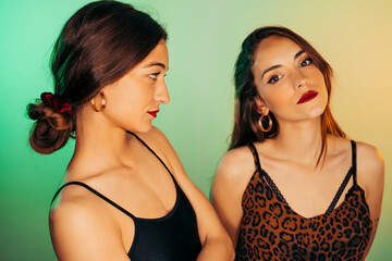 Portrait of two young women against green background