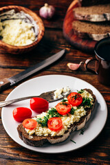 Rye bread toast with processed cheese, garlic and tomatoes