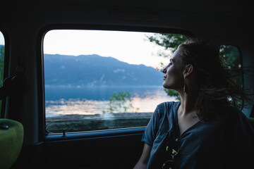 Young woman sitting on backseat in a car looking out of window