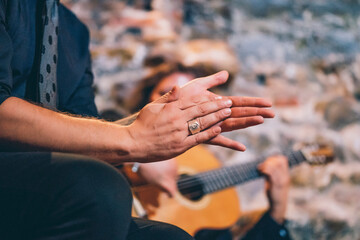 Close-up of singer clapping hands while man playing guitar in club - obrazy, fototapety, plakaty