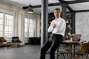 Portrait of mature businessman in loft office