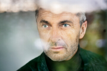 Close-up of thoughtful businessman with blue eyes looking away in office