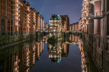 Germany, Hamburg, Speicherstadt, lighted old buildings with Elbe Philharmonic Hall in the background