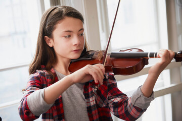 Girl playing violin during a lesson