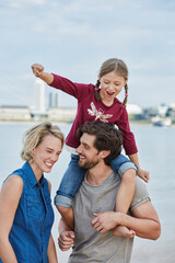 Germany, Duesseldorf, happy family with daughter at Rhine riverbank