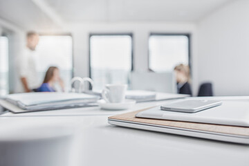 Stack of mobile devices and business people in office