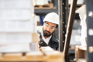Young man wearing hard hat working in a warehouse
