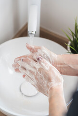 Close-up of woman washing her hand with soap