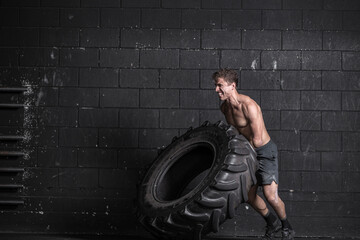 Athlete with an amputated arm exercising with tractor tire