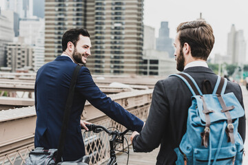 USA, New York City, two businessmen with bicycle on Brooklyn Bridge