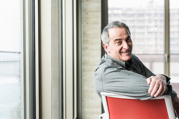 Senior businessman sitting on chair looking away
