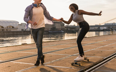 Young couple skateboarding at the riverside