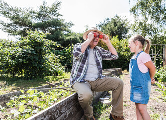 Playful grandfather with granddaughter in the garden