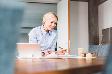 Smiling businesswoman working at desk in office