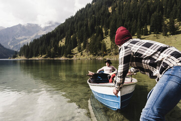Austria, Tyrol, Alps, couple with rowing boat on mountain lake