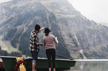 Austria, Tyrol, Alps, couple with map standing at mountain lake