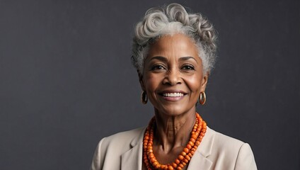 Smiling African-American senior businesswoman, wearing a beige blazer, pearl earrings, professional, elegant, grey background - obrazy, fototapety, plakaty