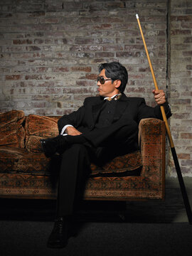 Portrait of Man on Sofa with Pool Cue