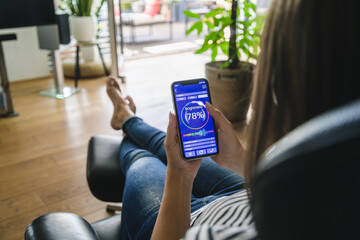 Young woman with smartphone with smart home control functions