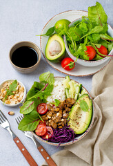 Vegetarian nutrition concept, bowl with healthy salad of rice, mushrooms, avocado, nuts, cherry tomatoes and lettuce. Healthy eating, self-care.