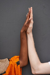 Couple joining hands in front of grey background