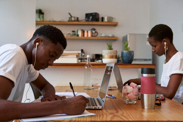 Young couple studying on table at home