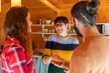 Host welcoming young couple in a cabin in the countryside handing over house key