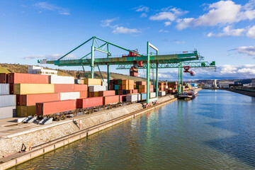 Germany, Baden-Wurttemberg, Stuttgart, Cargo containers stacked in commercial dock on bank of Neckar river - obrazy, fototapety, plakaty