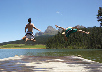 Men Jumping into Water from Dock