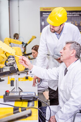 Two engineers examining industrial robot