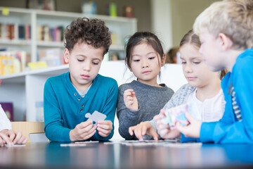 Pupils playing jigsaw puzzle in school together