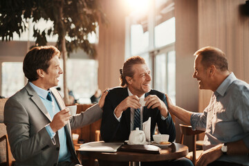 Businessmen Laughing and Enjoying Coffee Break Together