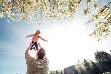 Father throwing little daughter in air - obrazy, fototapety, plakaty