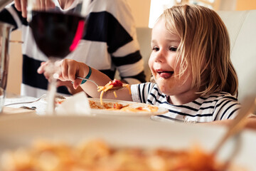 Portrait of happy little girl eating Spaghetti